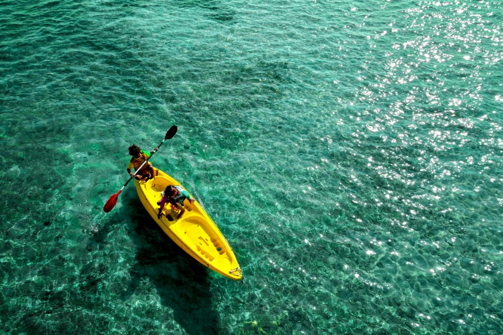 photo de deux personnes qui font du kayak dans le lagon aux eaux turquoises
